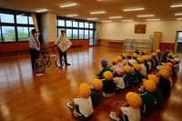 自転車点検の話を聞いている児童たちの写真