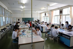 家庭科の授業で真剣に作業に取り組んでいる5年生の生徒たちの写真