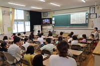 モニターを眺めている生徒たちの写真