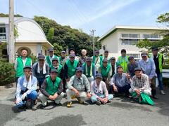 校舎前付近に複数の男性達が横3列に並んで立っている写真