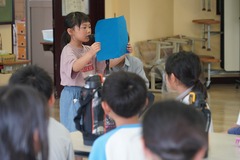 一学期の終業式で、代表の生徒が皆の前で作文を読み上げている写真