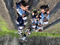 畑にサツマイモの畝を作り、みんなで記念撮影をしている写真