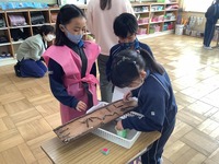 2年生が作ったおもちゃで遊んでいる1年生たちの写真
