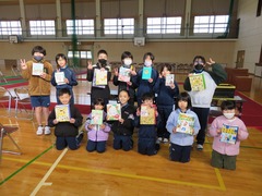 賞をもらった児童たちが賞品の手作りブックカバー袋を持っている写真