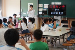 生徒たちの前で、水の事故や性被害についての注意をしている先生の写真