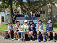 大きな木の前で記念撮影をしている講師の方と生徒たちの写真