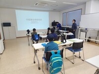 中部微生物研究所の所員さんから解説を聞いている子供たちの写真