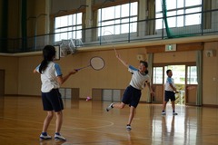体育館でバトミントンをしている子供たちの写真