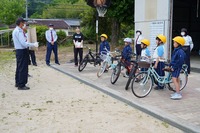 交通安全教室で指導員の方が生徒たちに自転車の講習をしている写真