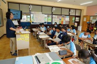 小学校の教室で、先生が生徒たちを相手に道徳の授業をしている写真