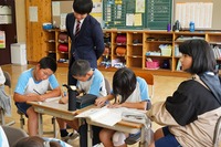 教室で、先生が生徒たちに授業を教えている写真