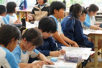 隣同士の4年生、5年生の生徒複数人が一緒に授業を考えている写真