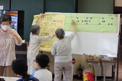 点筆の会「宮路」の講師の方が、生徒たちに点字を教えてる写真