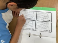 机に座り、課題のテキストを熟読している生徒の写真