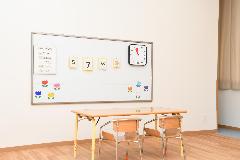 ホワイトボードや小さいテーブルが置かれている部屋の写真