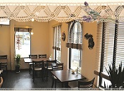 暖かなオレンジ色の照明と天井に飾り付けられたレースがおしゃれな認知症カフェの店内の写真