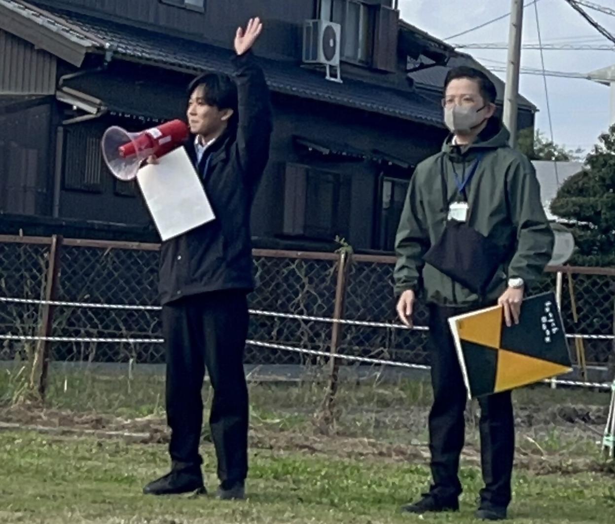 手を挙げている男性と、スケッチブックを持っている男性