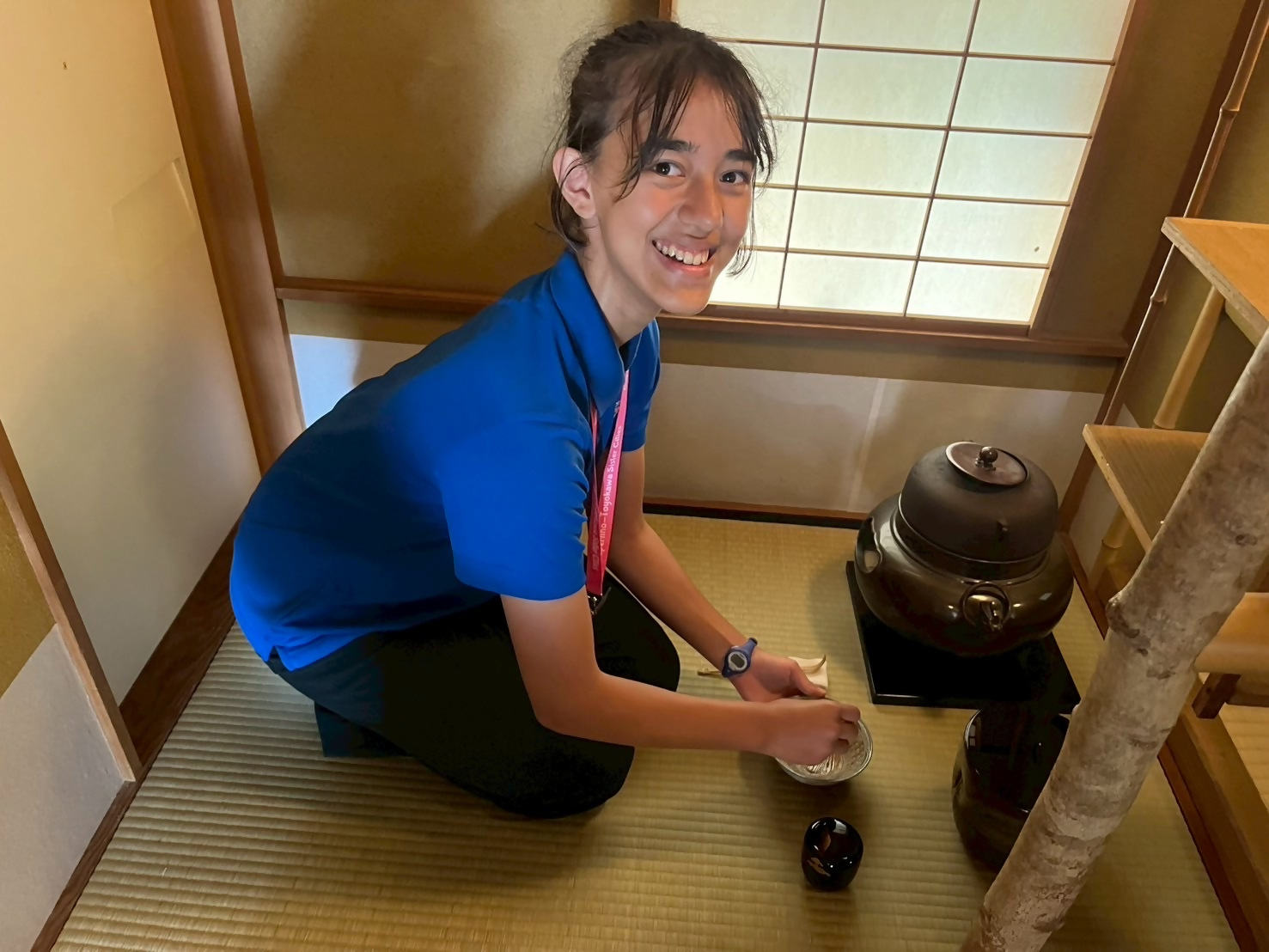 青い服を着た人がお茶をたてている写真