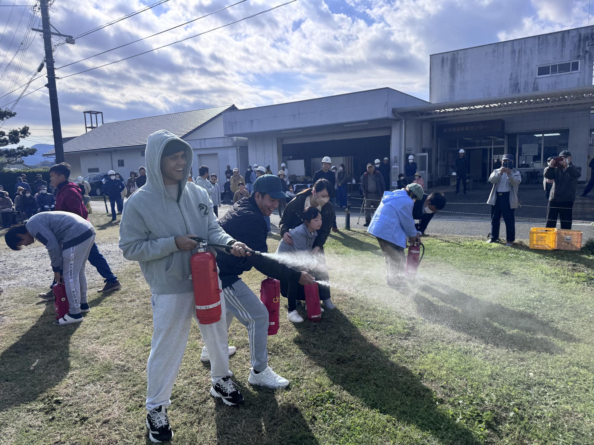 外国人や日本人が消火器を噴射している様子