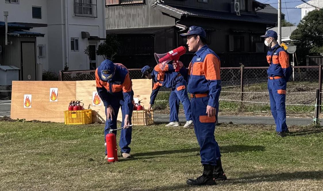 4人の消防士が消火器の使い方について説明している様子