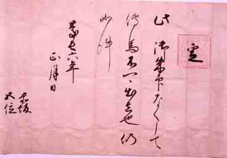 行書体の文字が書かれているピンク色の紙の写真