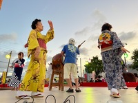 太鼓をたたいている人を中心に踊っている人たちの写真