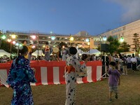 櫓の周りで踊っている浴衣姿の人たちの写真