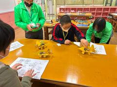 完成したロボットがうまく動くか動作確認をしている少年の写真