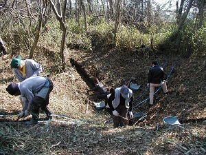 旧豊川海軍工廠近代遺跡調査事業で爆弾着弾地点の穴の調査をしている調査員たちの写真