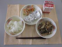 テーブルクロスに並べられたごはん・牛乳・いりどり・さばの銀紙焼き・三色なますの写真