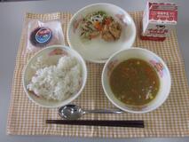テーブルクロスに並べられた麦ごはん・牛乳・米粉のカレースープ・バジルフライドチキン・やさいソテー・米粉のガトーショコラの写真