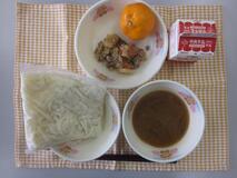 テーブルクロスに並べられた白玉うどん・牛乳・石狩風うどん・だいこんのそぼろあんかけ・みかんの写真