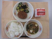 テーブルクロスに並べられたごはん・牛乳・すまし汁・キャベツメンチカツ・ひじきと大豆のサラダの写真