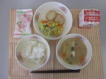 テーブルクロスに並べられたごはん・牛乳・白みそ汁・もち麦入りはんぺん・やさい炒め・ひなあられの写真
