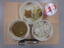 テーブルクロスに並べられた麦ごはん・はっこう乳・米粉のカレーライス・切り干しだいこんのサラダ・福神漬の写真