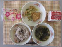 テーブルクロスに赤はん・牛乳・すまし汁・とりのから揚げ・ごまあえ・米粉のいちごクレープ並べられたの写真