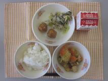 テーブルクロスに並べられたごはん・牛乳・やさいのふくめ煮・ごぼう入りつくね・赤しそあえの写真