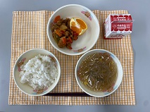 テーブルクロスに並べられたごはん・牛乳・はるさめスープ・酢ぶた・きよみみかんの写真