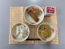 テーブルクロスに並べられたごはん・牛乳・かきたまスープ・愛知のやさいはるまき・もやしソテーの写真