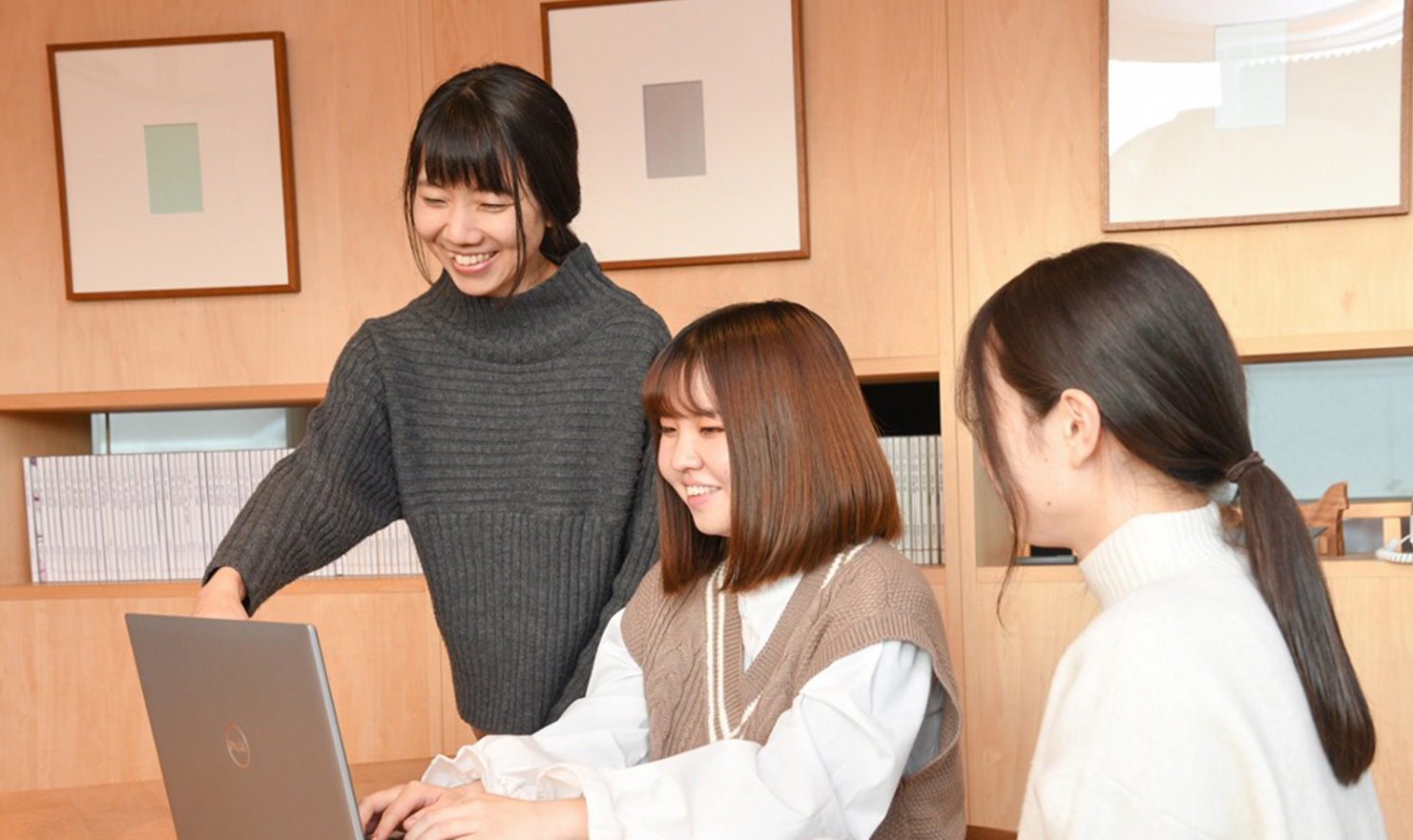 パソコンを女性三人で楽しそうに操作している写真