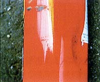赤い消火器の側面にへこみが生じている写真