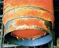 消火器の底周辺の黒いさびを落としてもなお腐食が残っている写真