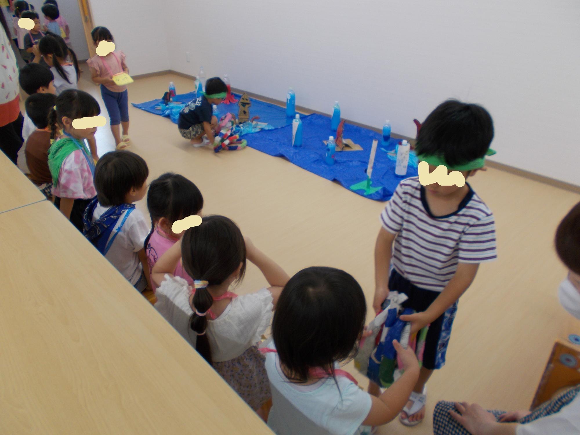 お店屋さんの年長児が小さい子にやさしく声をかけている