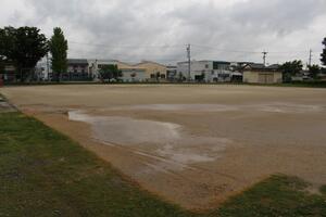 小学校の校庭に大きい水溜まりが写っている写真