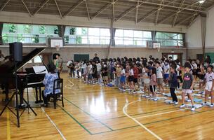 児童たちが足を大きく広げて立ち歌っている写真