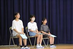 3人の児童がパイプ椅子に座っている写真