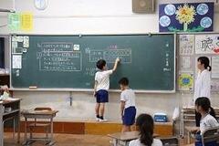 児童が黒板に図を描いている写真