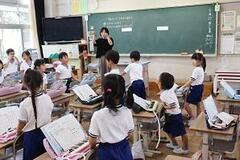 児童たちが教室で鍵盤ハーモニカを使用している写真
