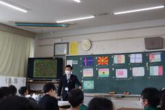 社会の授業をしている先生と生徒たちの写真
