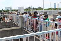 晴天の中浄化センターの設備を興味深そうに見学する児童達の写真
